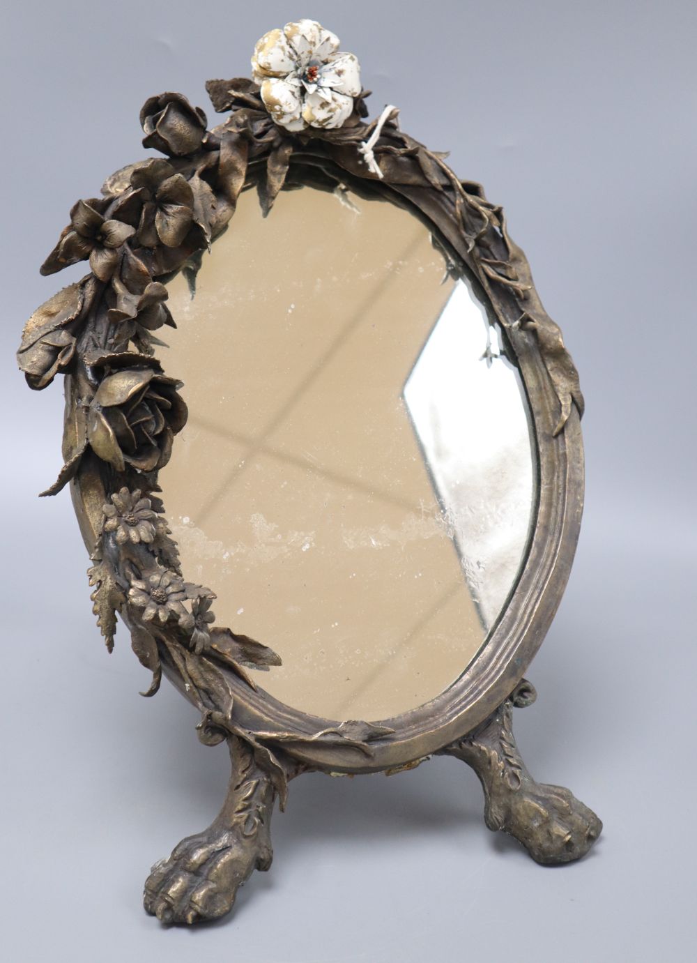 A floral bronze oval easel mirror, with single enamelled flower, length 41cm